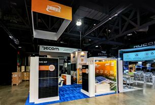 Emmvee completed booth: a rectangular hanging sign above upright solar panels and counters
