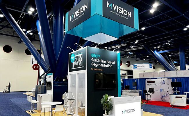 MVISION completed booth: a rectangular overhead sign supported above display walls and counters