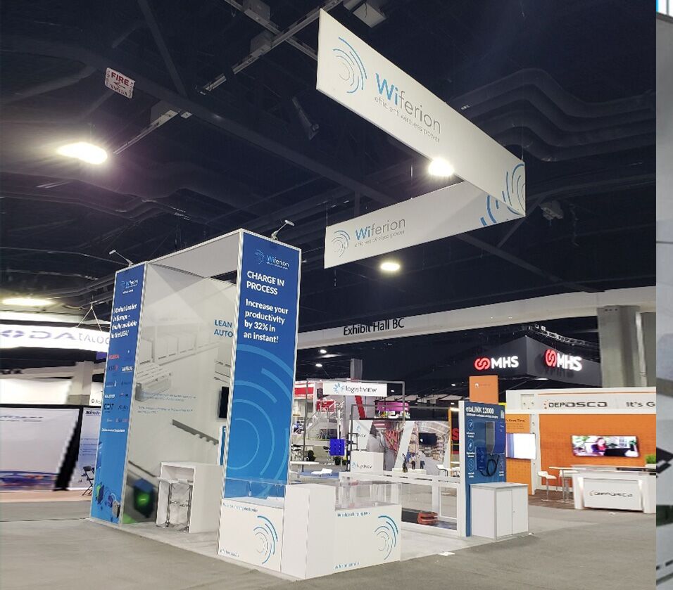Wiferion completed booth: an angular hanging sign above a tall central tower and product counters