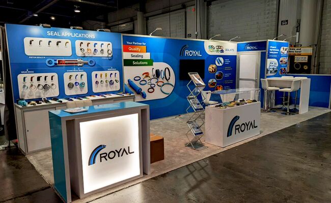 Royal Composites completed booth: wall-mounted product samples behind a long reception counter