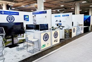 Yonsei completed booth: a corner display wall with graphic panels, seating and a reception counter