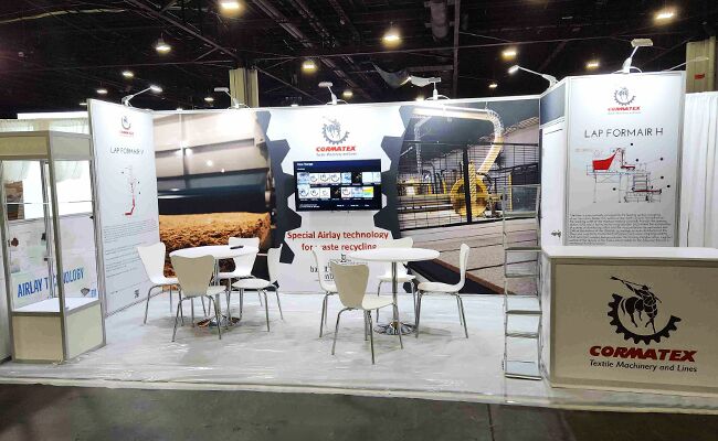 Cormatex completed booth: product samples mounted on wall panels around a central meeting area