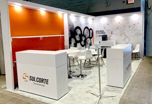 Sulcorte completed booth: circular saw-blade displays on the back wall above a counter and meeting table