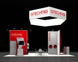 Front view of a Gtechniq booth with red product displays, a square hanging sign and a central meeting table.