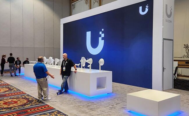 UI completed booth: a broad back wall with a reception desk across the open front