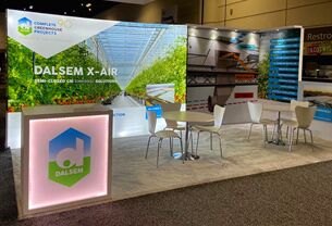 Dalsem completed booth: a greenhouse graphic back wall behind a reception counter and meeting table