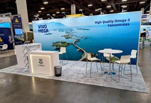 G.C. Rieber completed booth: a coastal graphic back wall behind a reception counter and café table