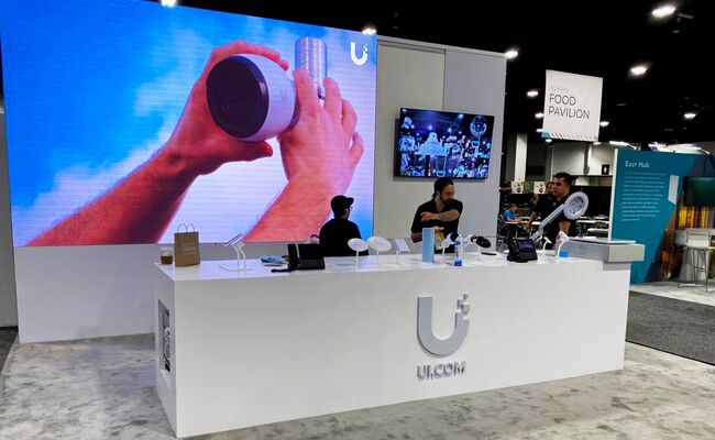 UI completed booth: a large video wall behind a long reception counter