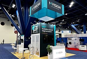 MVISION completed booth: a rectangular overhead sign supported above display walls and counters