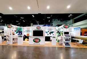 DMA completed booth: a long overhead frame above graphic panels and product-display stations