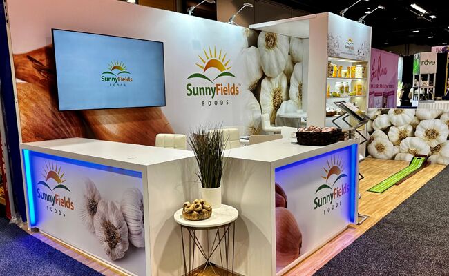 Rabbex LLC completed booth: tiered display walls with floral graphics, a front counter and a round table