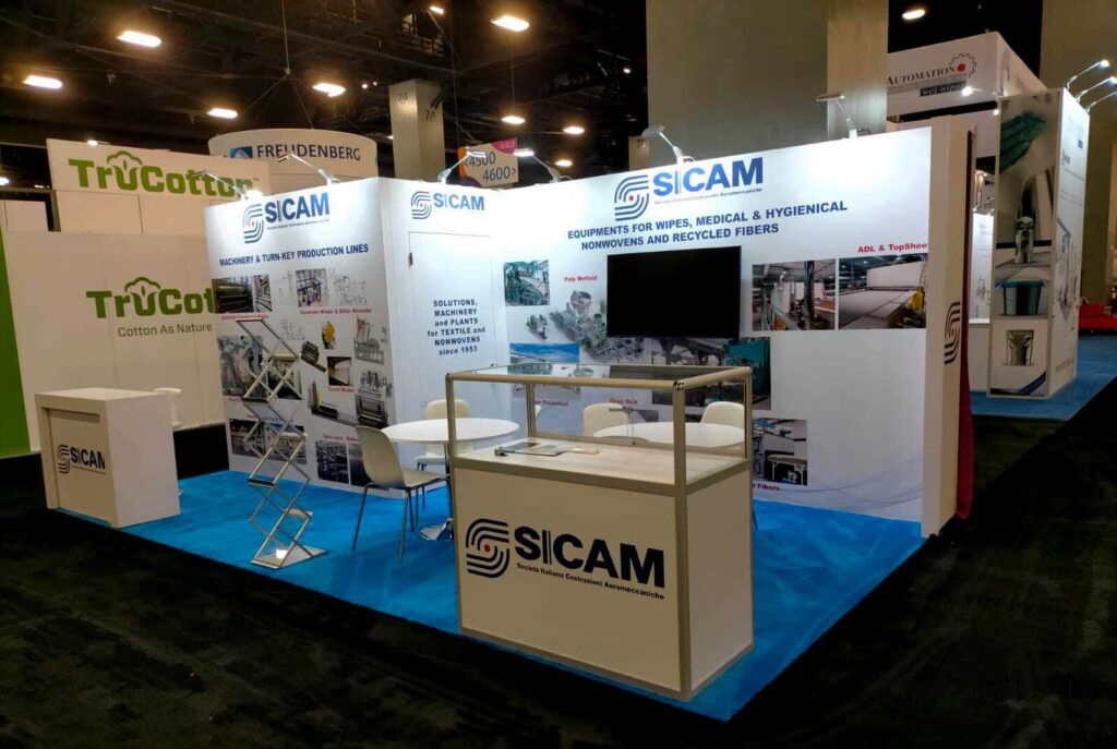 SICAM completed booth: a wide graphic wall beneath a long overhead sign with display counters