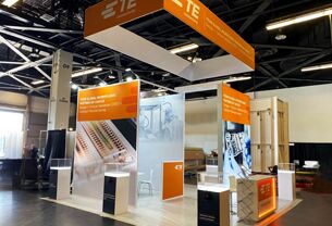 TE CONNECTIVITY completed booth: a rectangular hanging sign above a tall central product-display tower