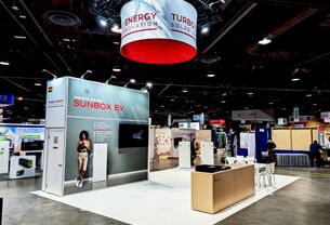 Turbo Energy completed booth: a circular hanging sign above product displays and reception counters