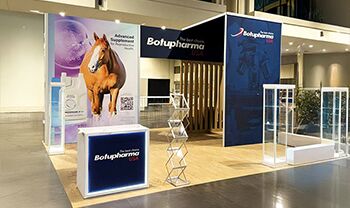 Botupharma completed booth: a tall graphic wall beside a reception counter and stools