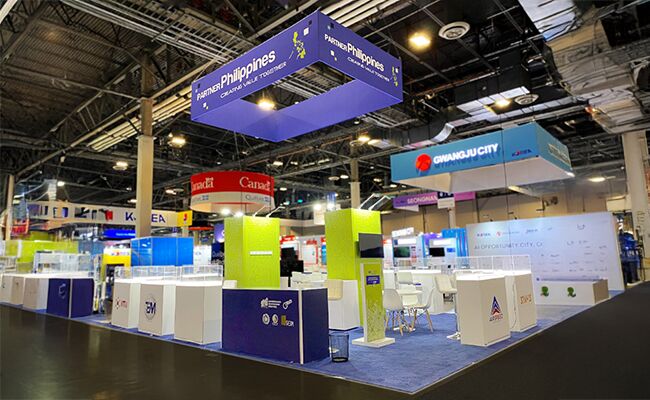 Philippines Pavilion (CITEM) completed booth: a suspended rectangular sign above product displays and reception counters