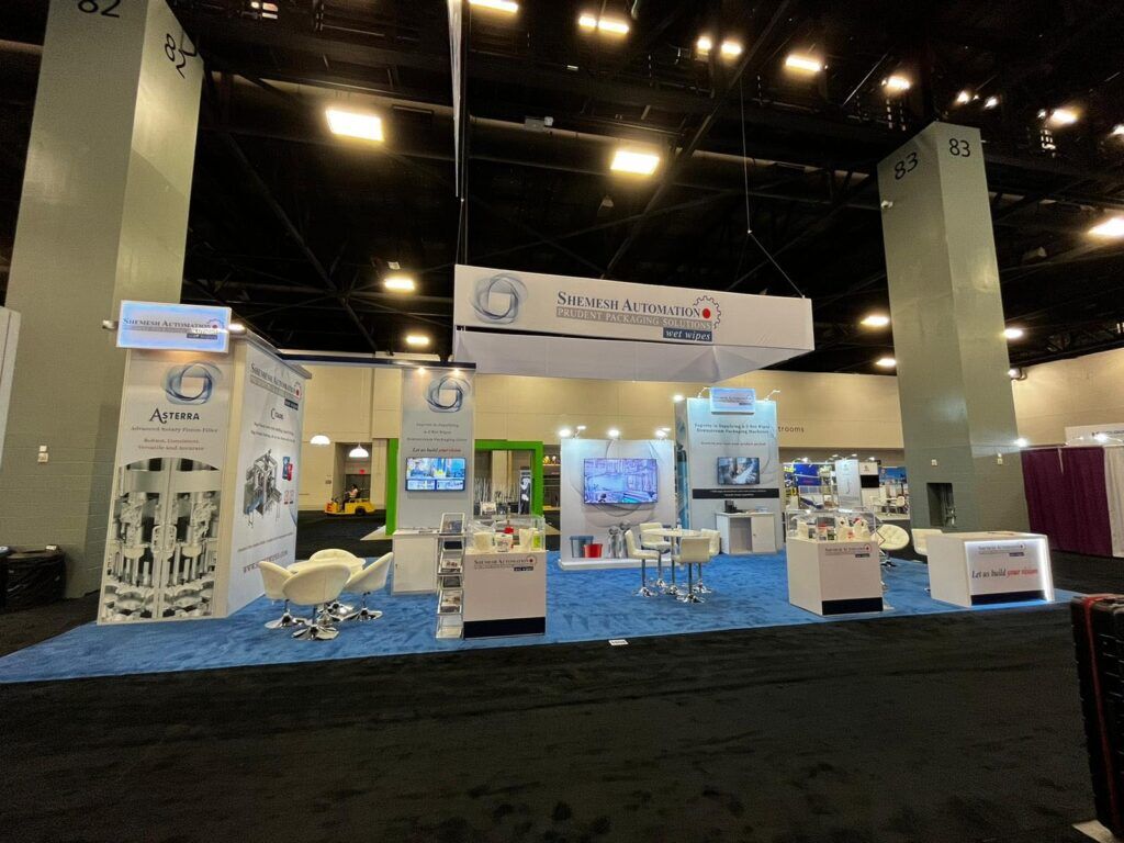 Shemesh Automation completed booth: a suspended sign above information panels, display equipment and a counter