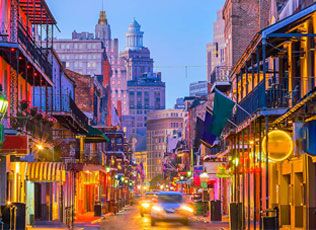 New Orleans street with colorful balconies and the cathedral in the distance