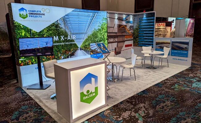 Dalsem completed booth: a greenhouse graphic back wall behind a reception counter and meeting area