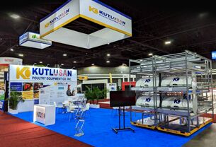 Kutlusan completed booth: a rectangular hanging sign over a long equipment display