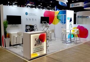 AIDENCE completed booth: an angular overhead frame surrounding product shelves and a reception counter