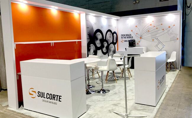 Sulcorte completed booth: circular saw-blade displays on the back wall above a counter and meeting table