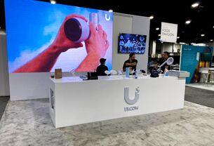 UI completed booth: a large video wall behind a long reception counter
