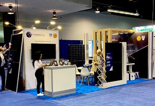 Philadelphia Solar completed booth: upright solar panels between slatted posts, with a screen and reception desk