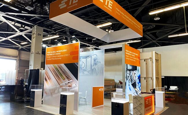TE CONNECTIVITY completed booth: a rectangular hanging sign above a tall central product-display tower