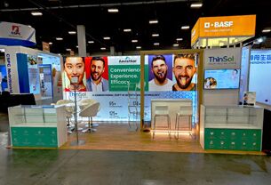Aavishkar completed booth: a long graphic wall with screens above counters and bar stools