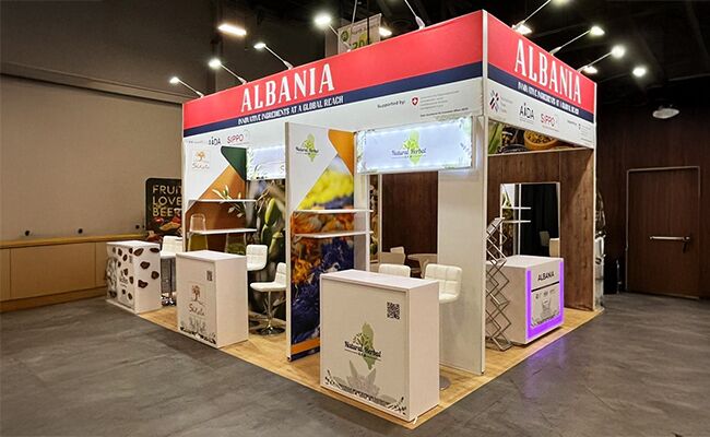 AL -International Trade Centre completed booth: a rectangular canopy framing product displays and reception counters