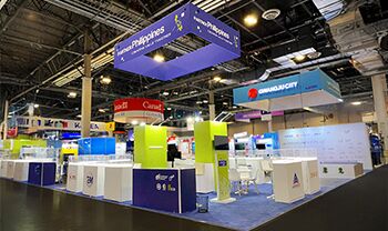 Philippines Pavilion (CITEM) completed booth: a suspended rectangular sign above product displays and reception counters
