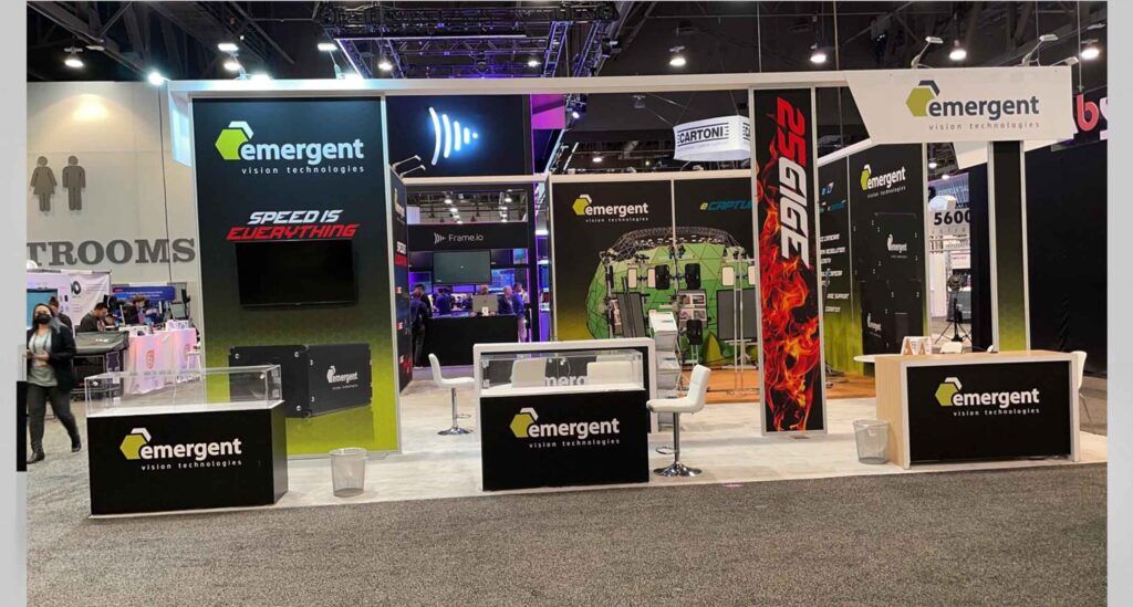 Emergent Vision Technologies completed booth: a screen and product displays set into a corner graphic wall