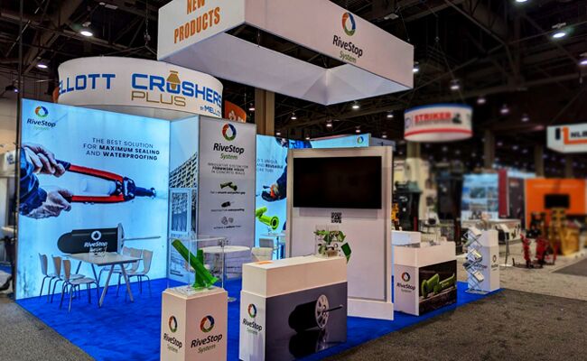 Rivestop completed booth: a rectangular hanging sign above freestanding product panels and a meeting area