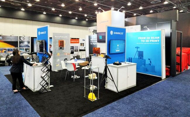 Shining 3D completed booth: a tall central tower and graphic back wall around product-display pedestals