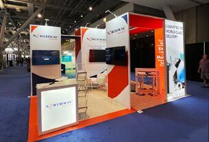Northway Biotech completed booth: angled display walls around a screen, reception desk and meeting tables