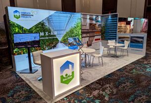 Dalsem completed booth: a greenhouse graphic back wall behind a reception counter and meeting area